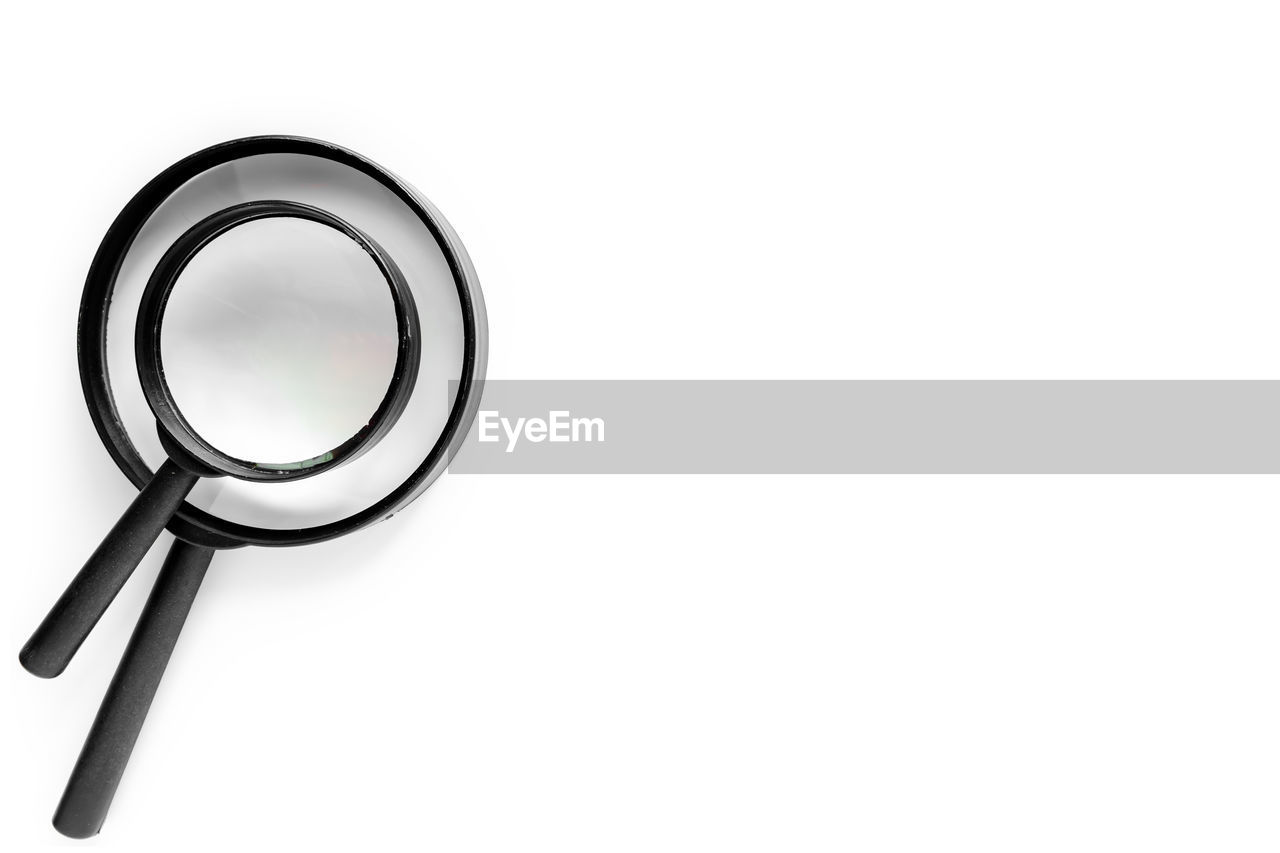 Close-up of magnifying glasses against white background