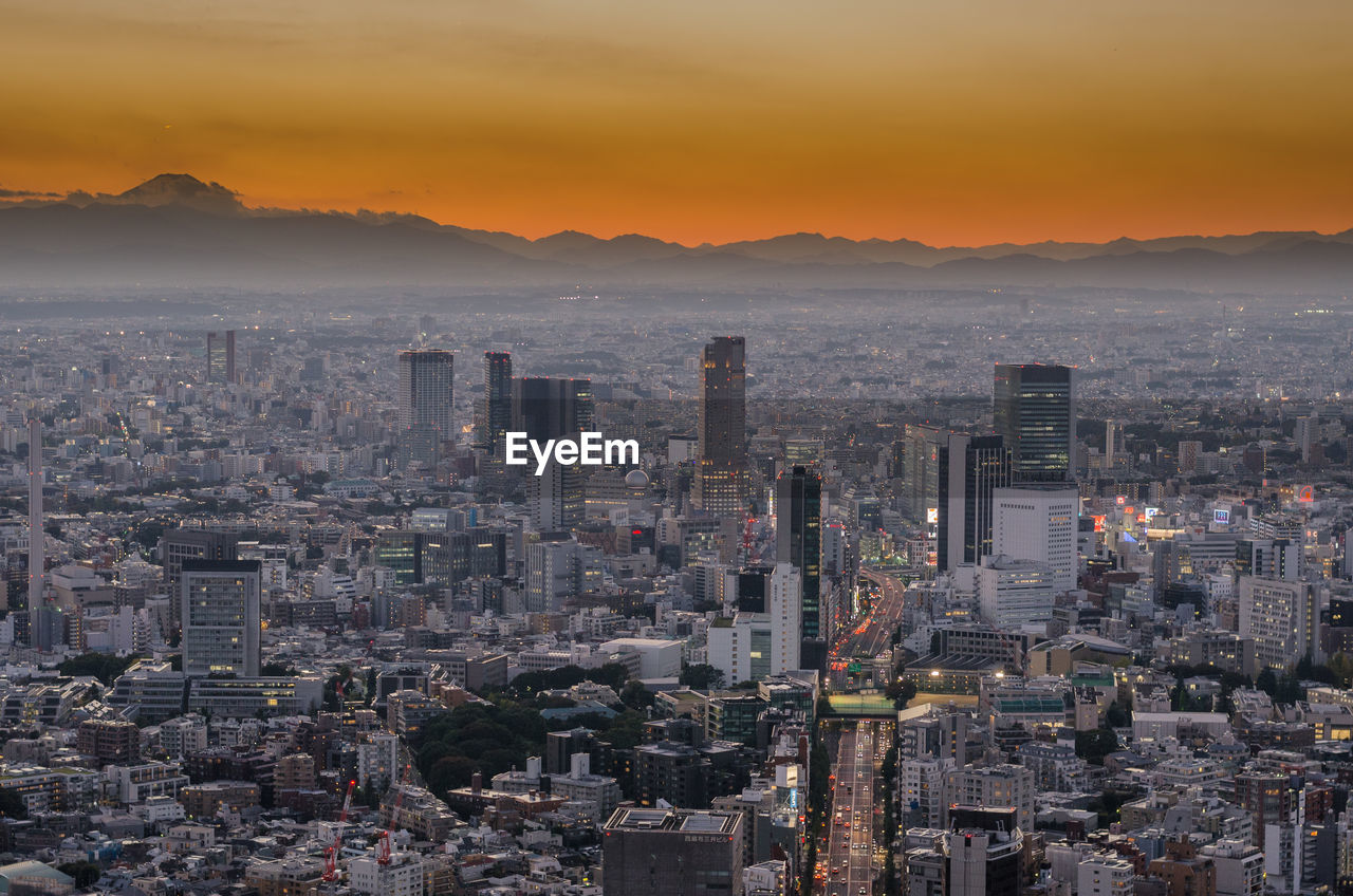 Aerial view of buildings in city during sunset