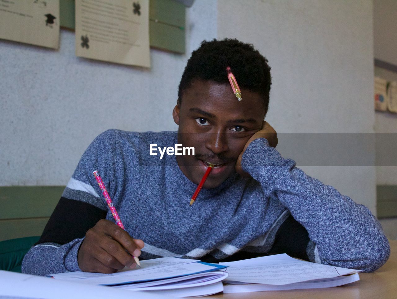 Portrait of young man studying on table at home