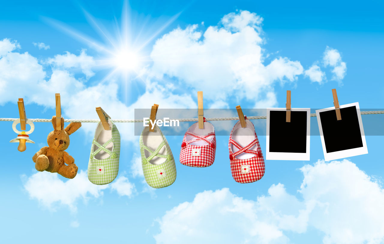 cloud, sky, blue, nature, group of objects, no people, hanging, screenshot, multi colored, shoe, sunlight, outdoors, cartoon, copy space