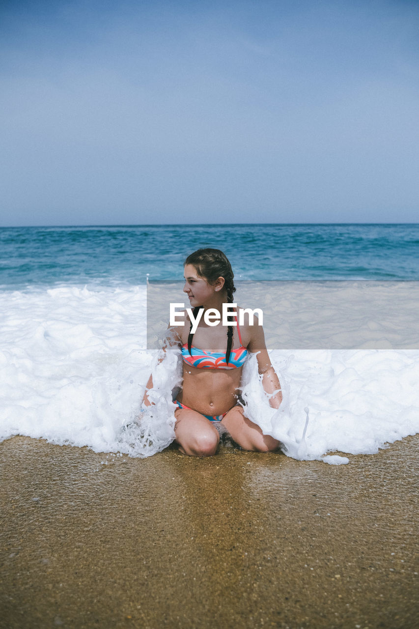 Bikini model posing on the beach with the waves