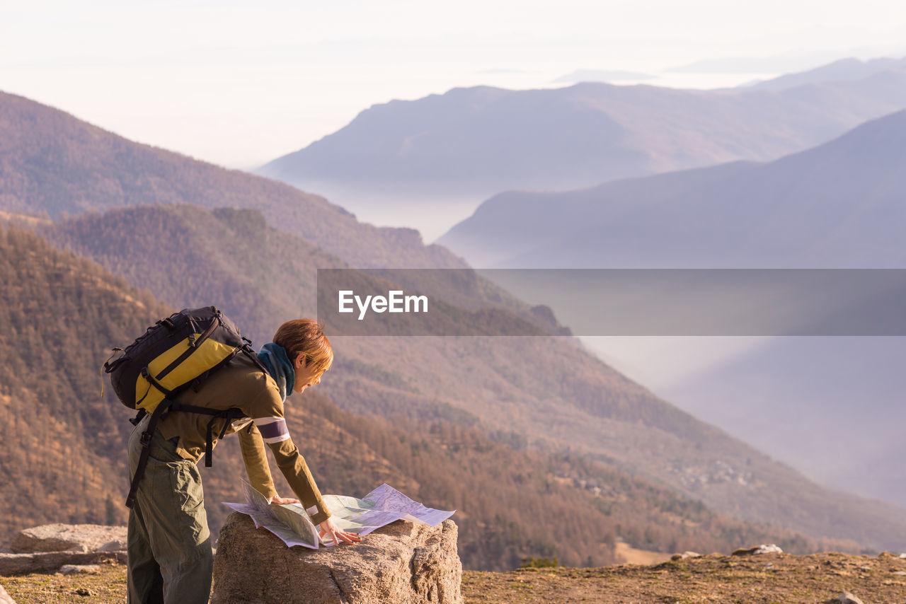 Woman looking at map on landscape