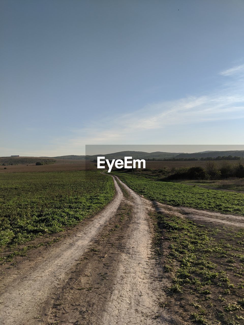 Road amidst field against sky