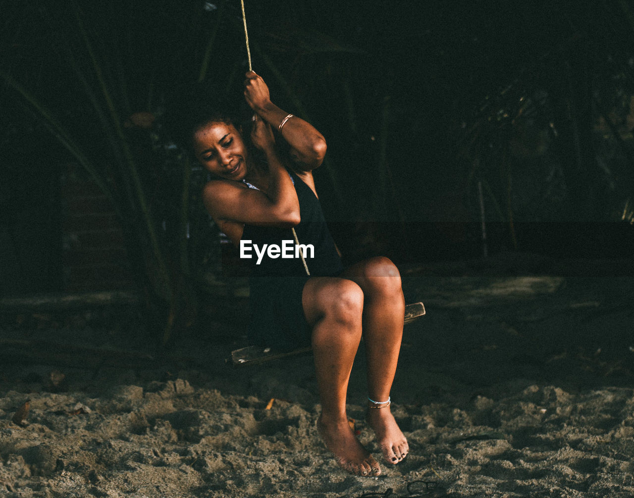 YOUNG WOMAN SITTING IN WATER AT PARK