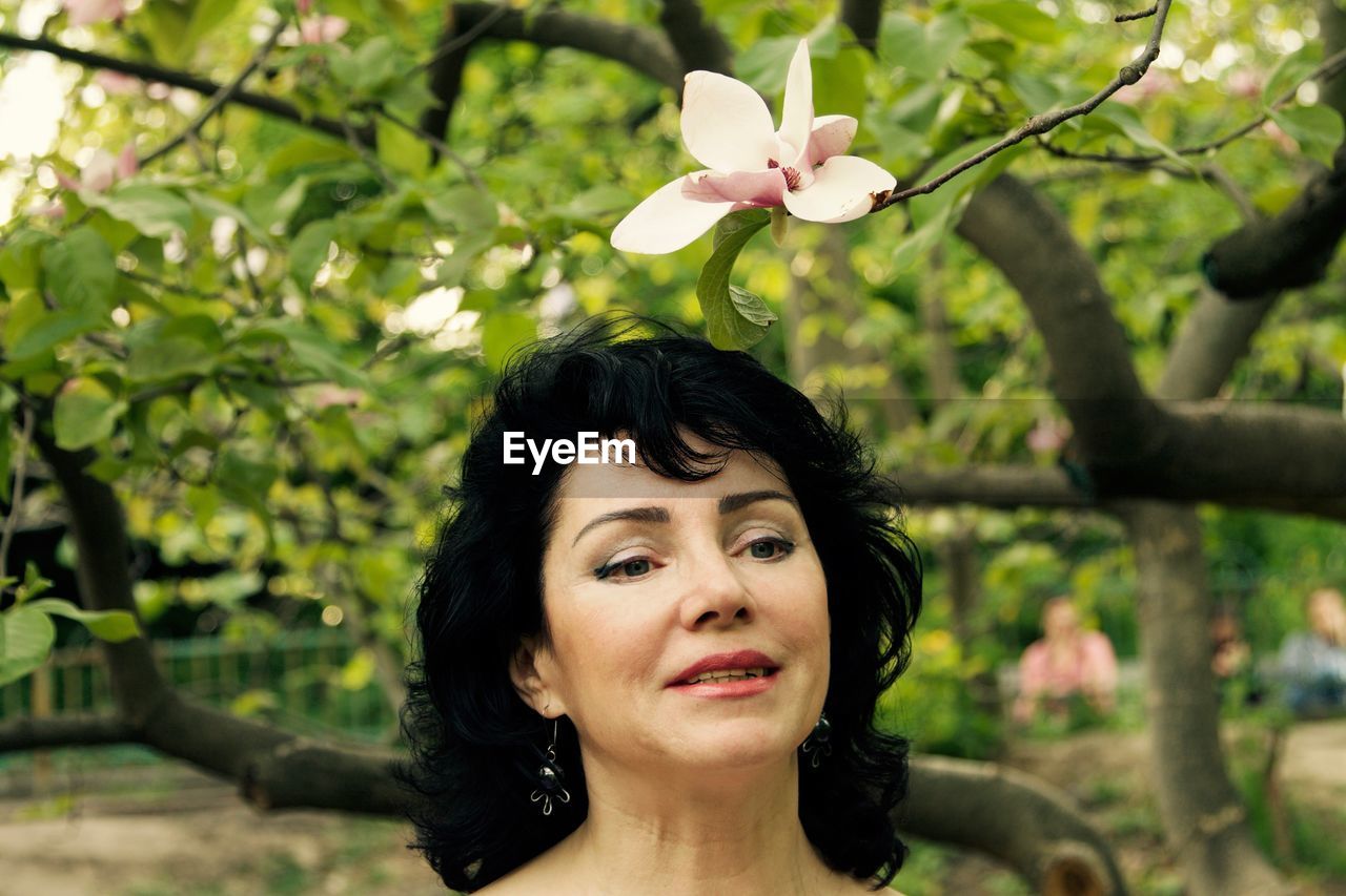 Smiling woman by plants looking away