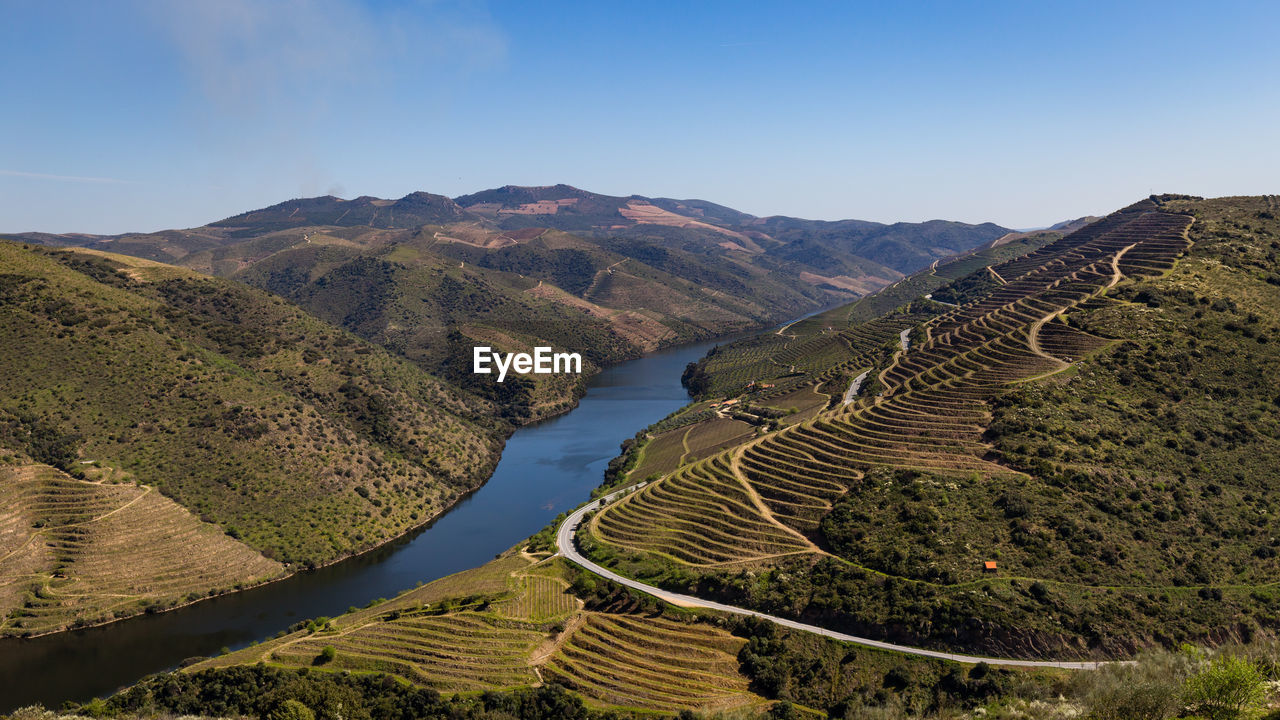 High angle view of field and mountains against clear sky