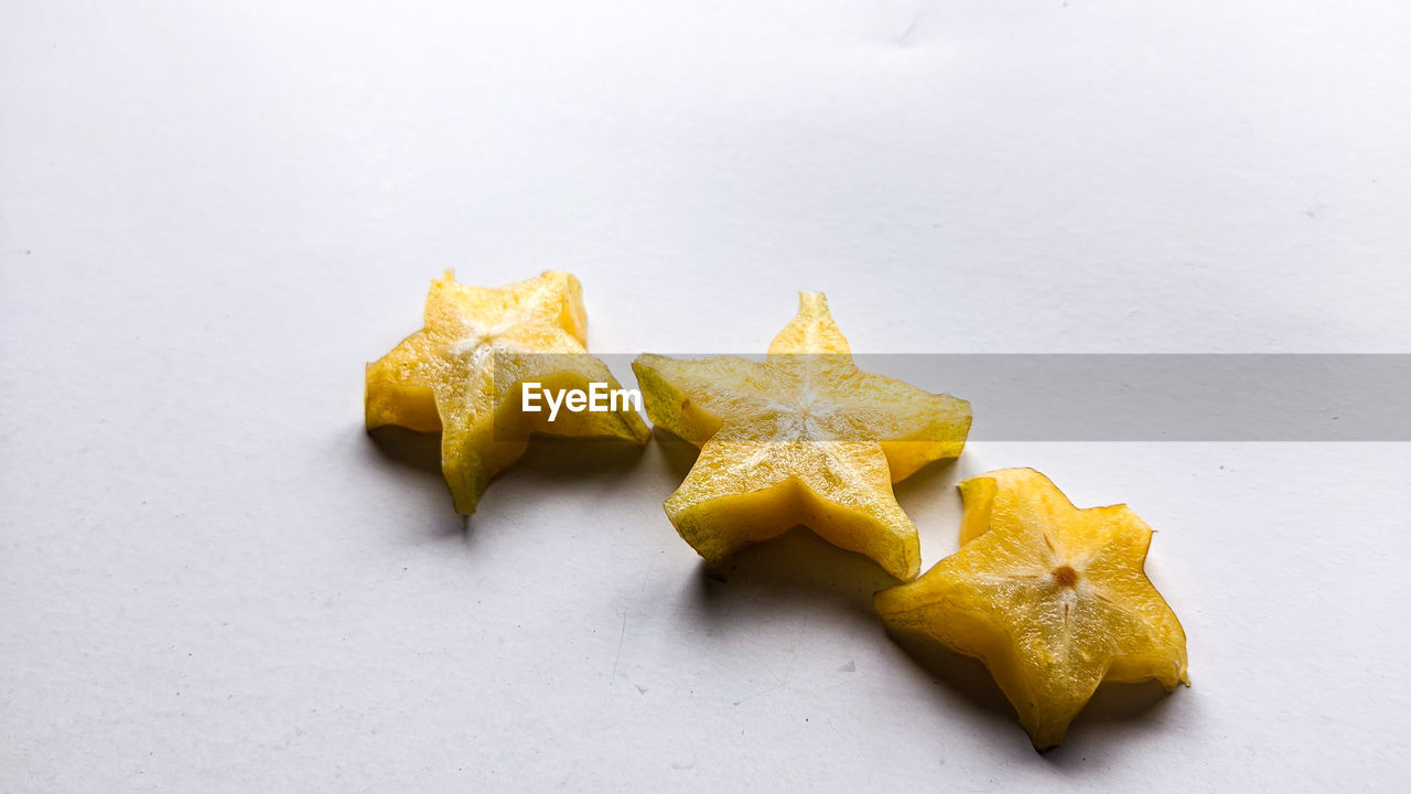 yellow, food and drink, food, leaf, star shape, produce, plant, no people, indoors, shape, studio shot, freshness, still life, group of objects, high angle view, close-up