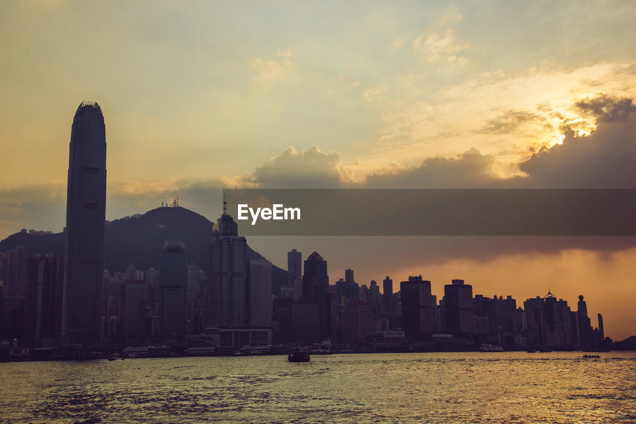 SCENIC VIEW OF SEA AND BUILDINGS AGAINST SKY AT SUNSET