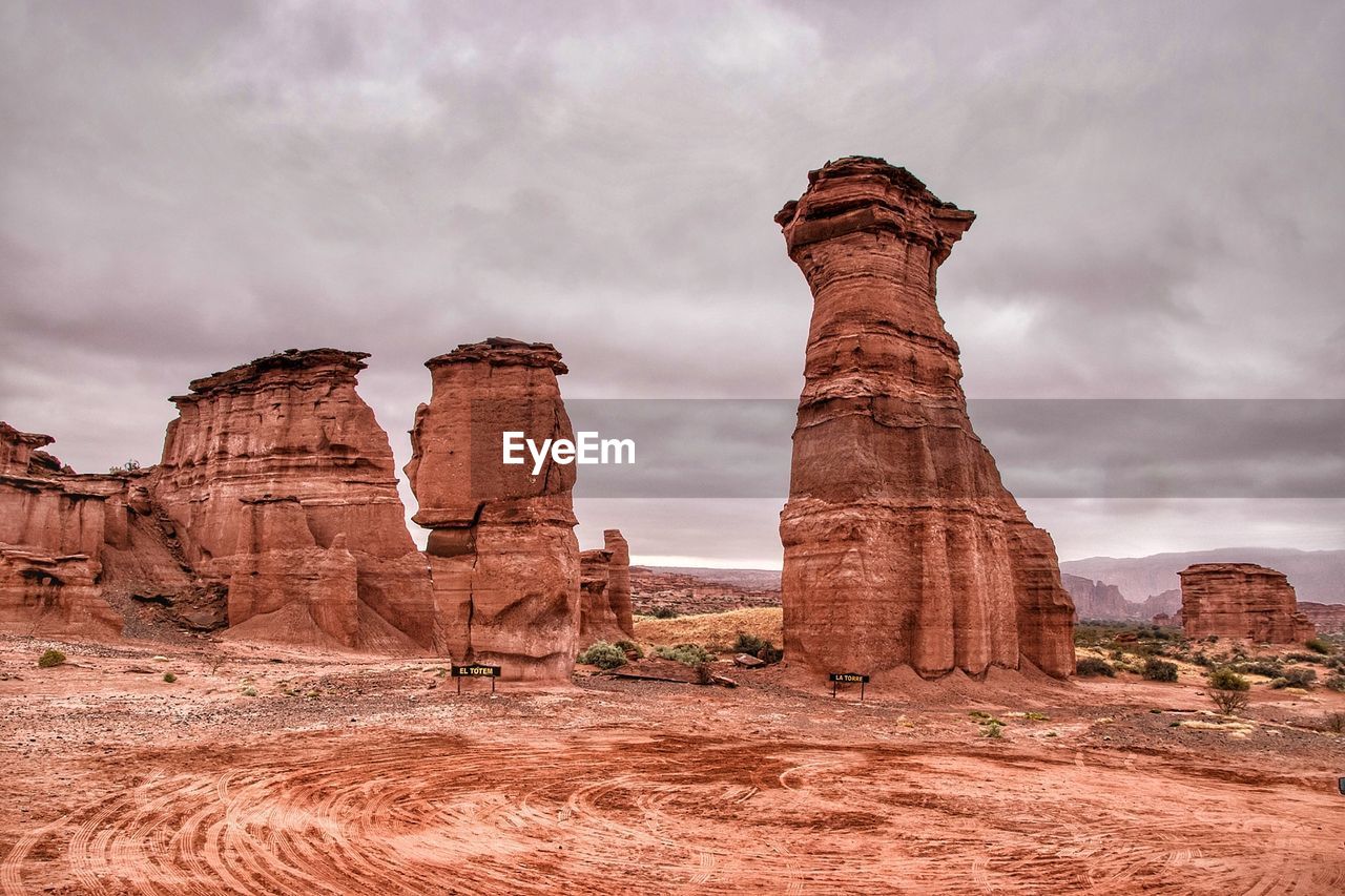 Rock formations against cloudy sky