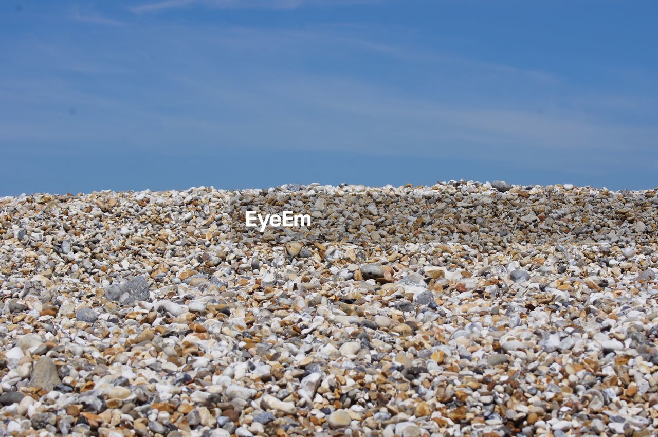 Rocks on beach against blue sky