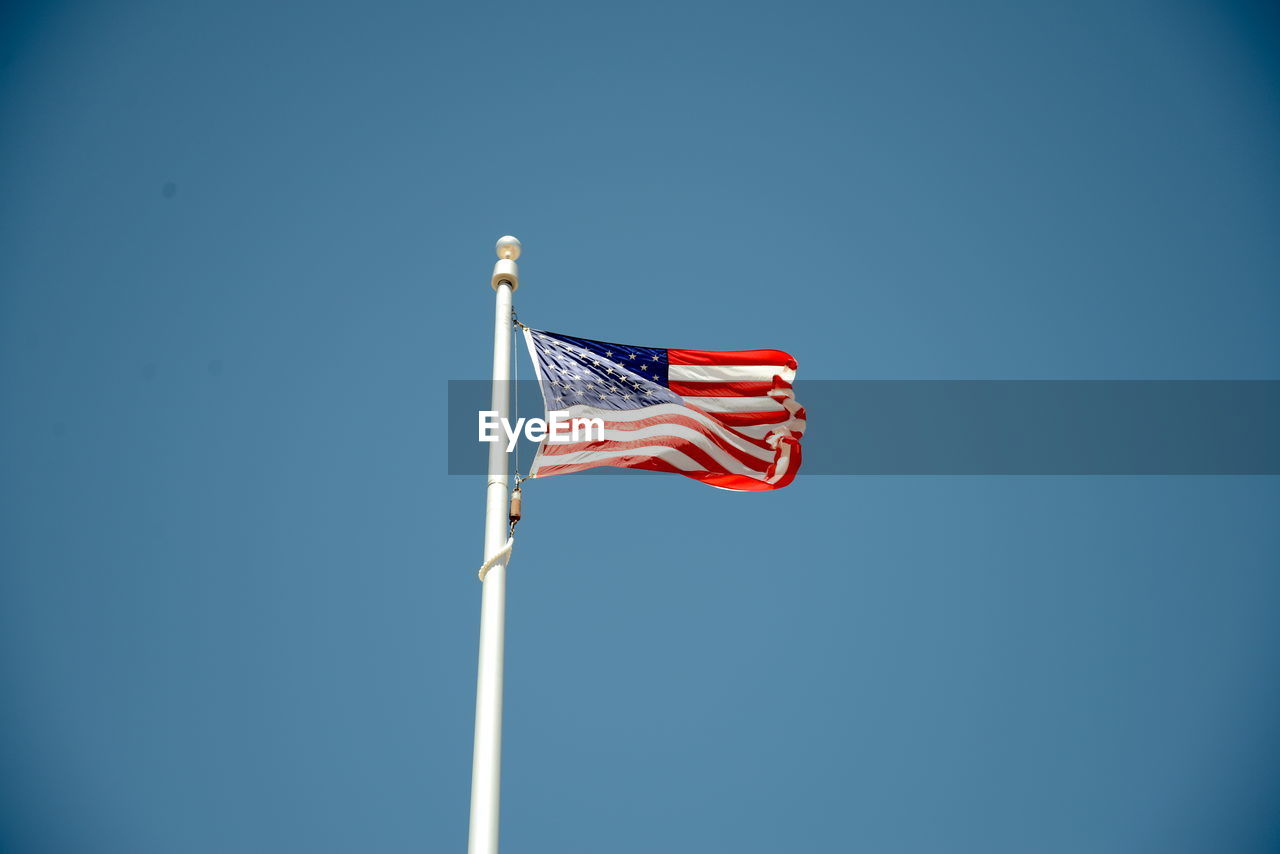 Low angle view of american flag against clear sky