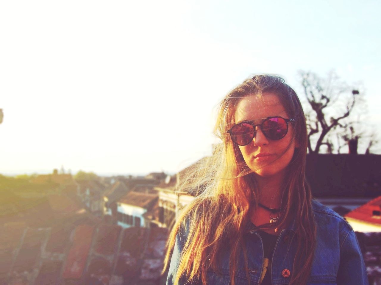 Portrait of young woman wearing sunglasses against sky