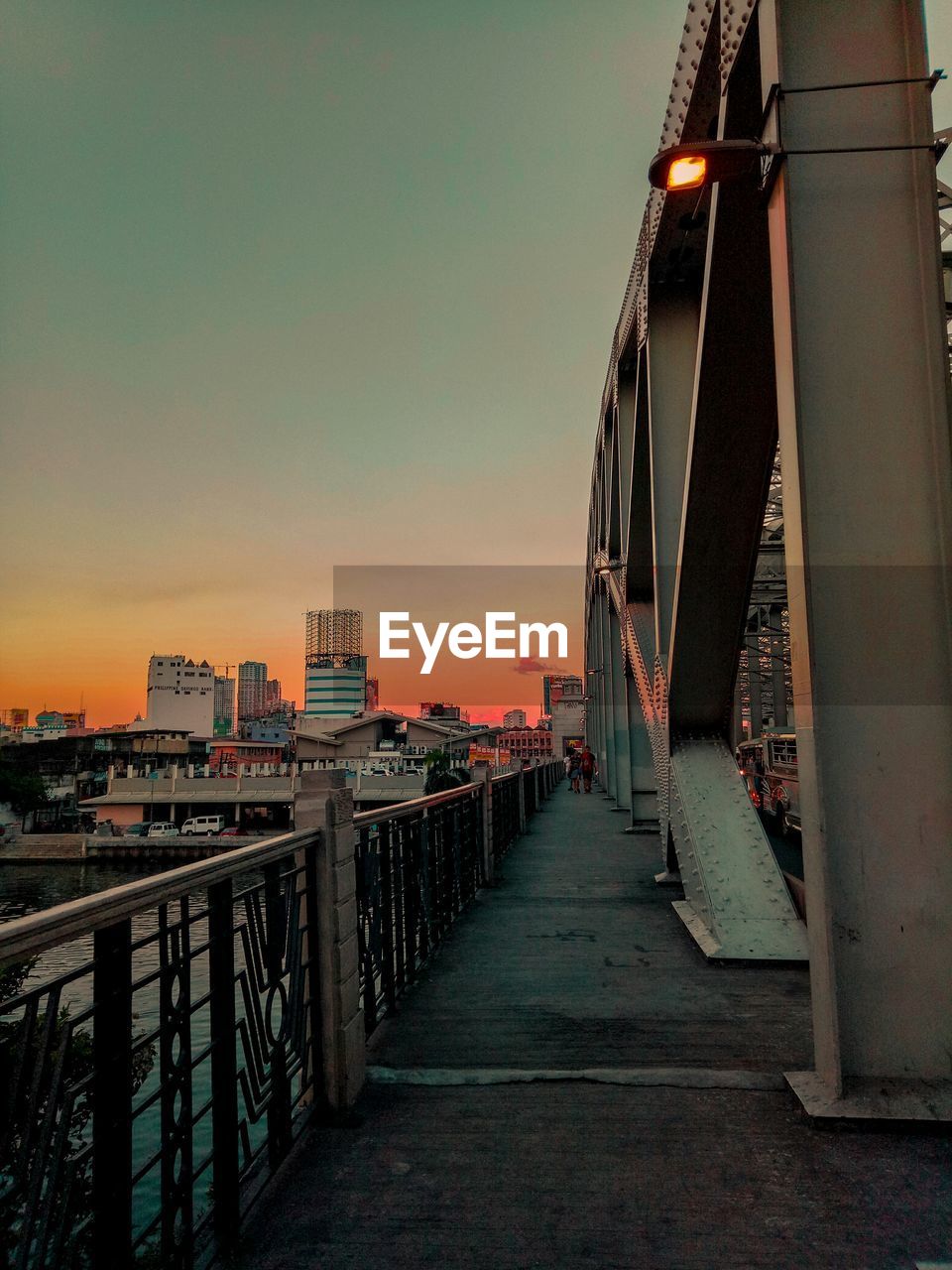 VIEW OF BRIDGE AND BUILDINGS AGAINST SKY AT SUNSET