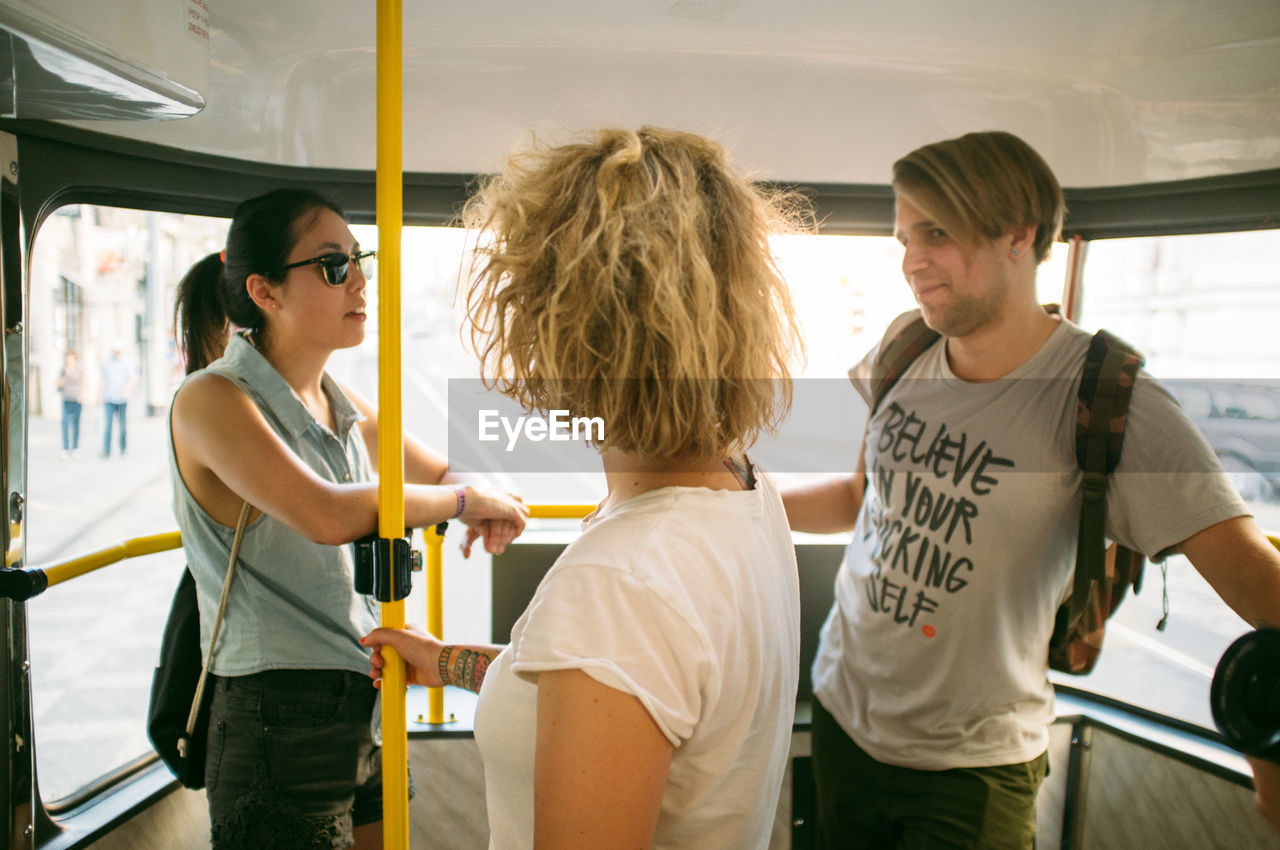 Friends talking while standing in bus