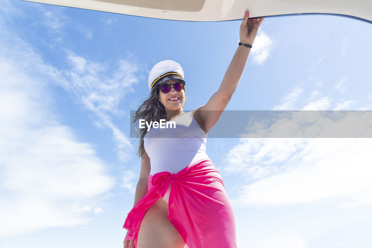 A woman on top of a boat against the sea in the background. 