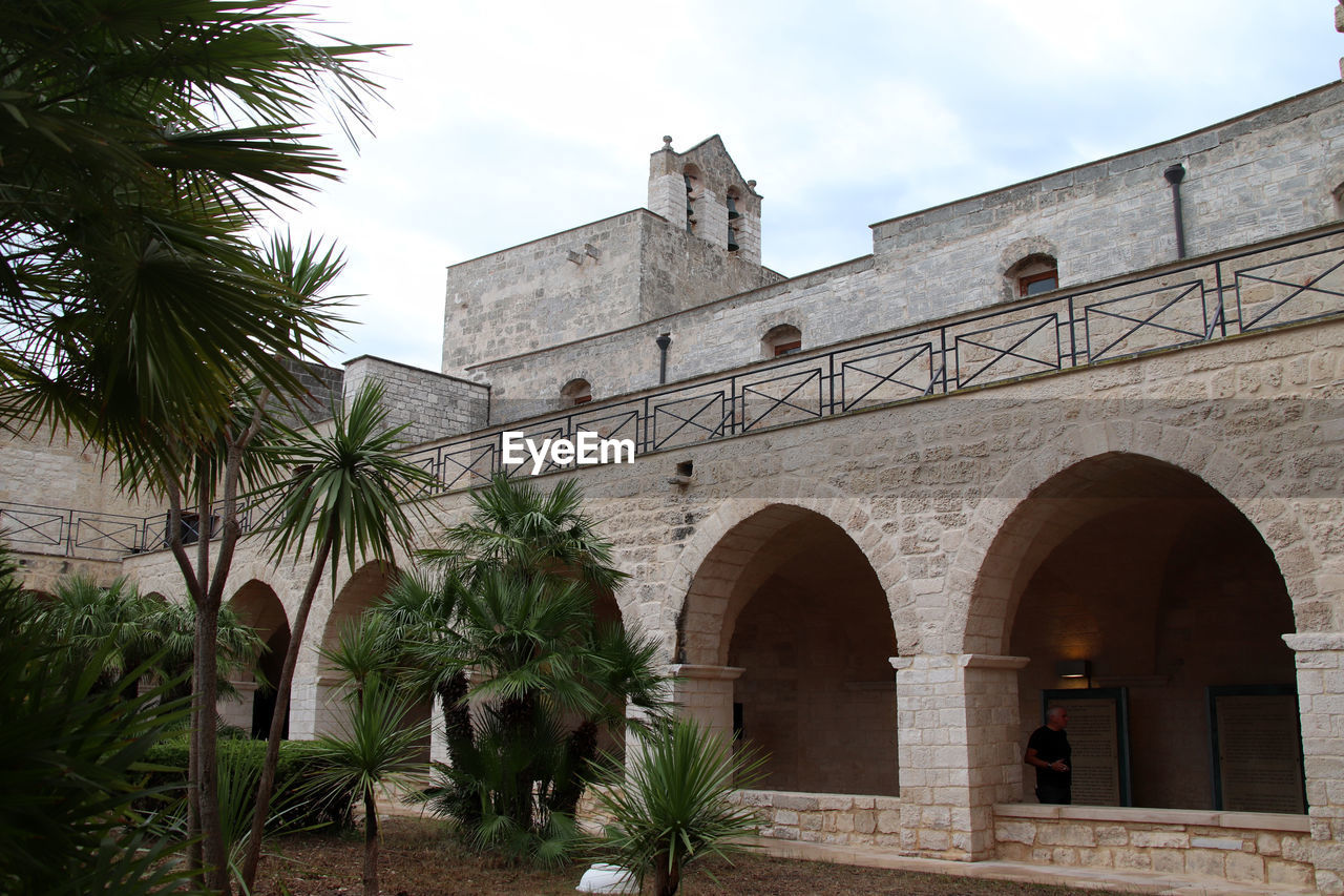 architecture, palm tree, built structure, building exterior, arch, tropical climate, plant, tree, nature, building, travel destinations, history, the past, place of worship, ancient history, sky, hacienda, no people, travel, outdoors, religion, estate, city, day, entrance, tourism