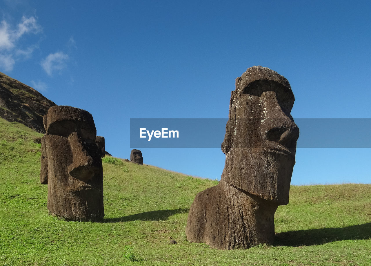 Moai statue on field against sky
