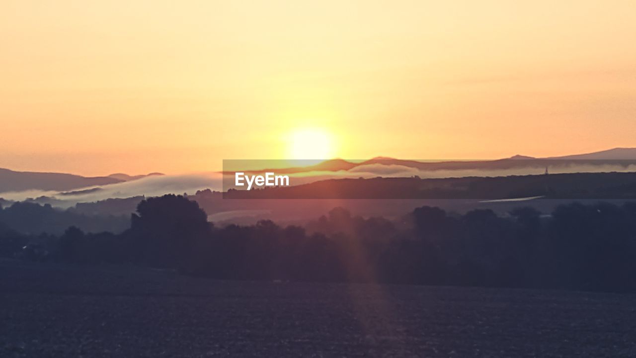 SCENIC VIEW OF MOUNTAINS AGAINST SKY DURING SUNSET