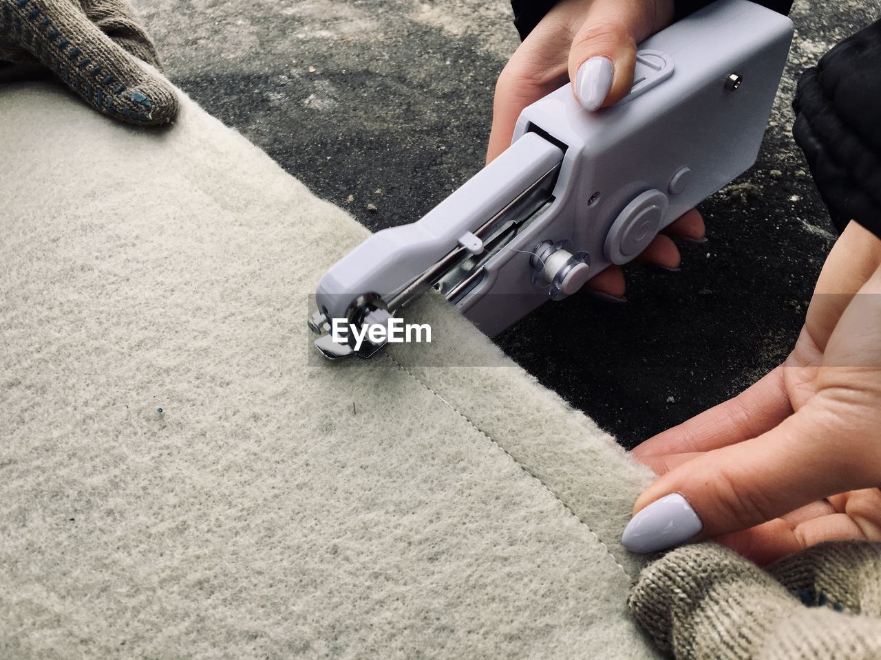 Cropped image of woman sewing carpet
