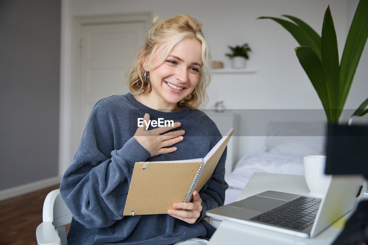 portrait of young woman using digital tablet while sitting at home