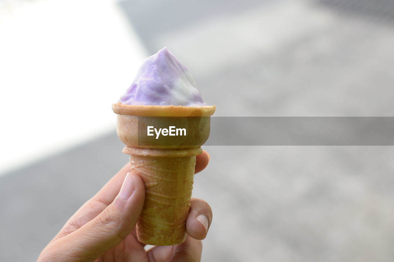 Close-up of hand holding ice cream cone