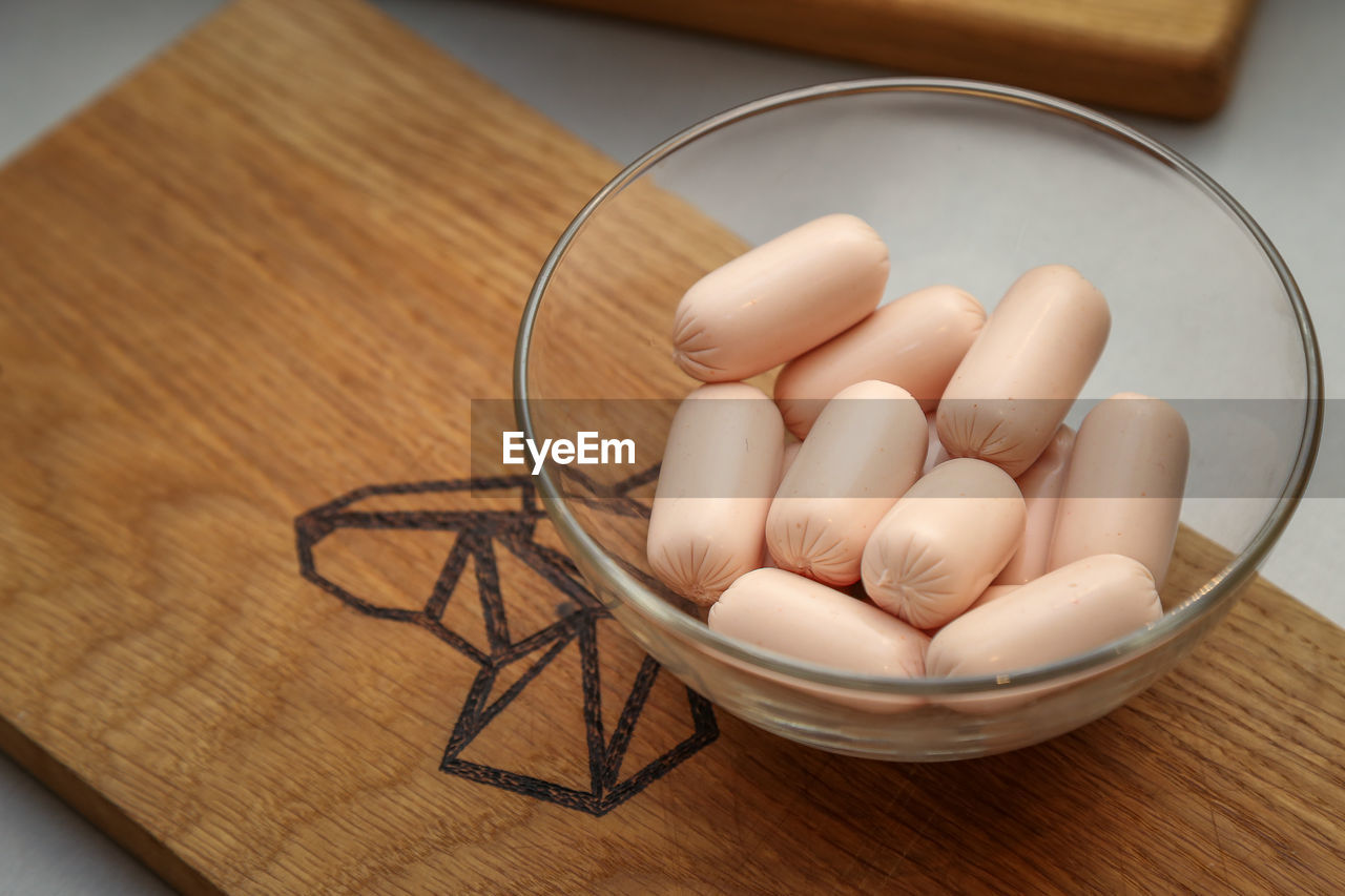 HIGH ANGLE VIEW OF EGGS IN CONTAINER ON WOODEN TABLE