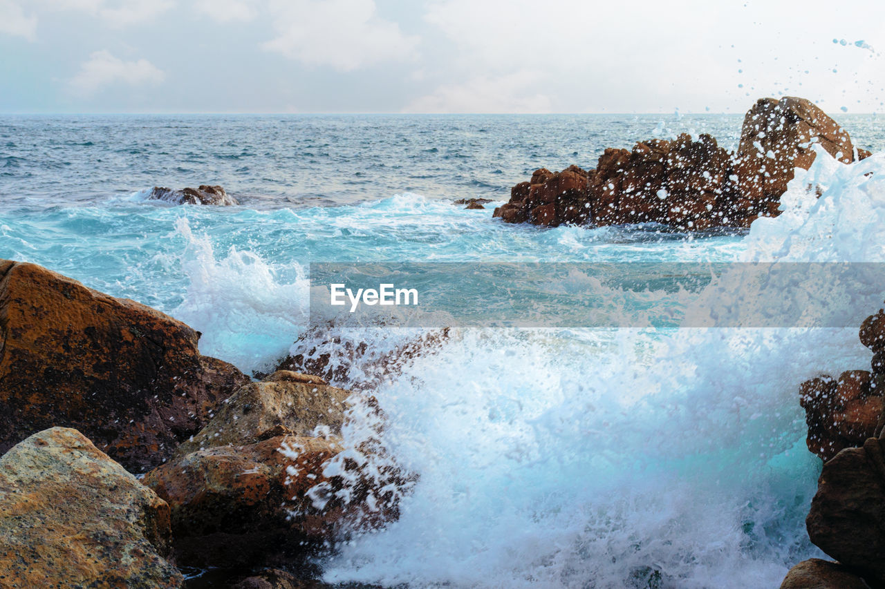 Sea landscape, wave and rocks. stormy waves crashing into rocks. waves foam. water splash ocean.
