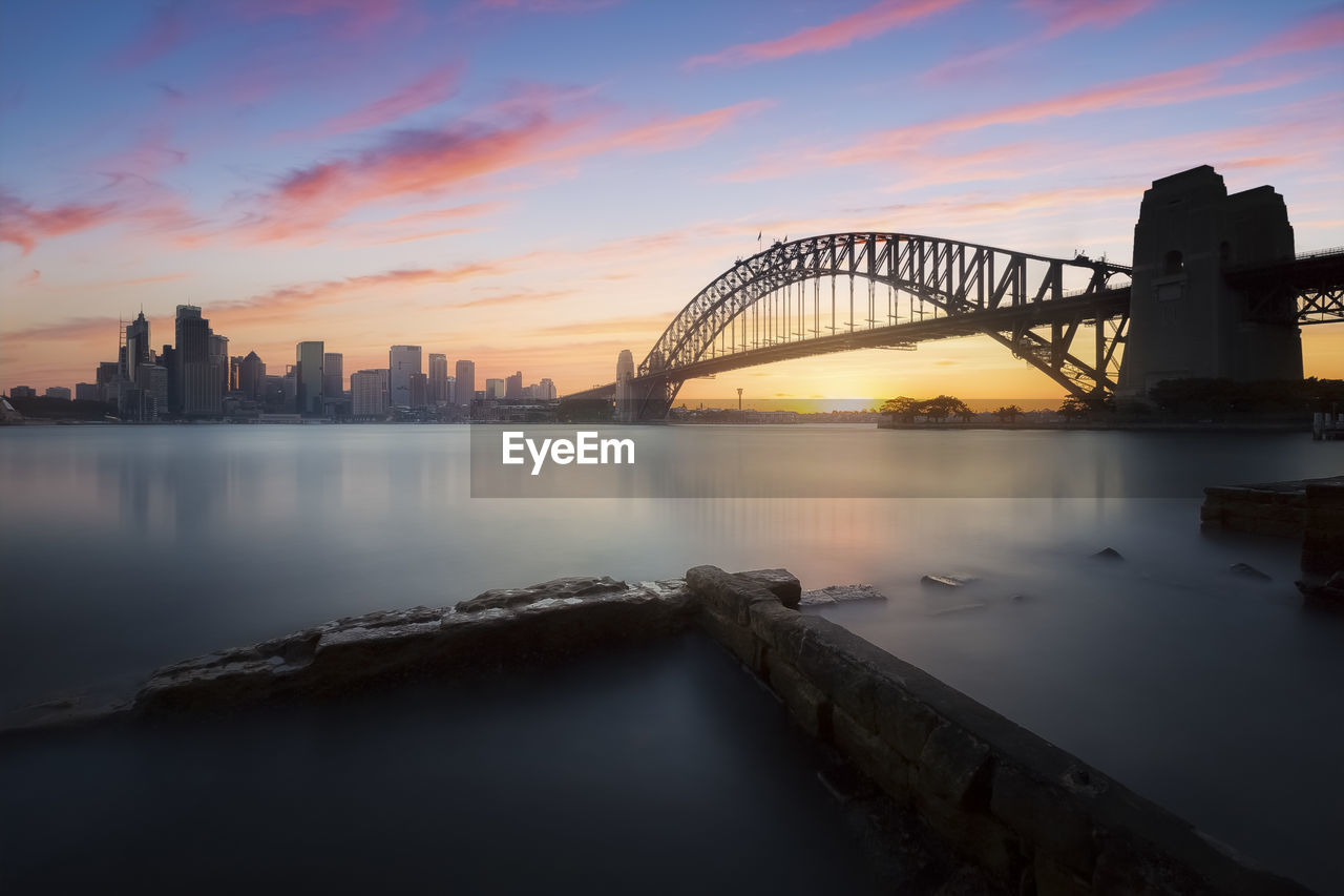Cityscape of sydney city and sydney harbour bridge at sunset in new south wales, australia