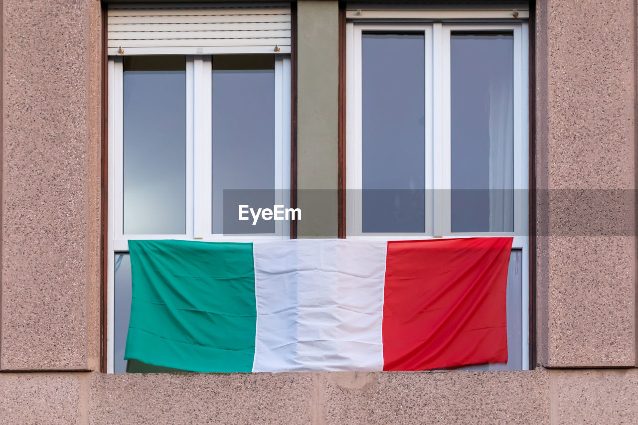 The italians locked up in the quarantined house display the rainbow flag on the windows