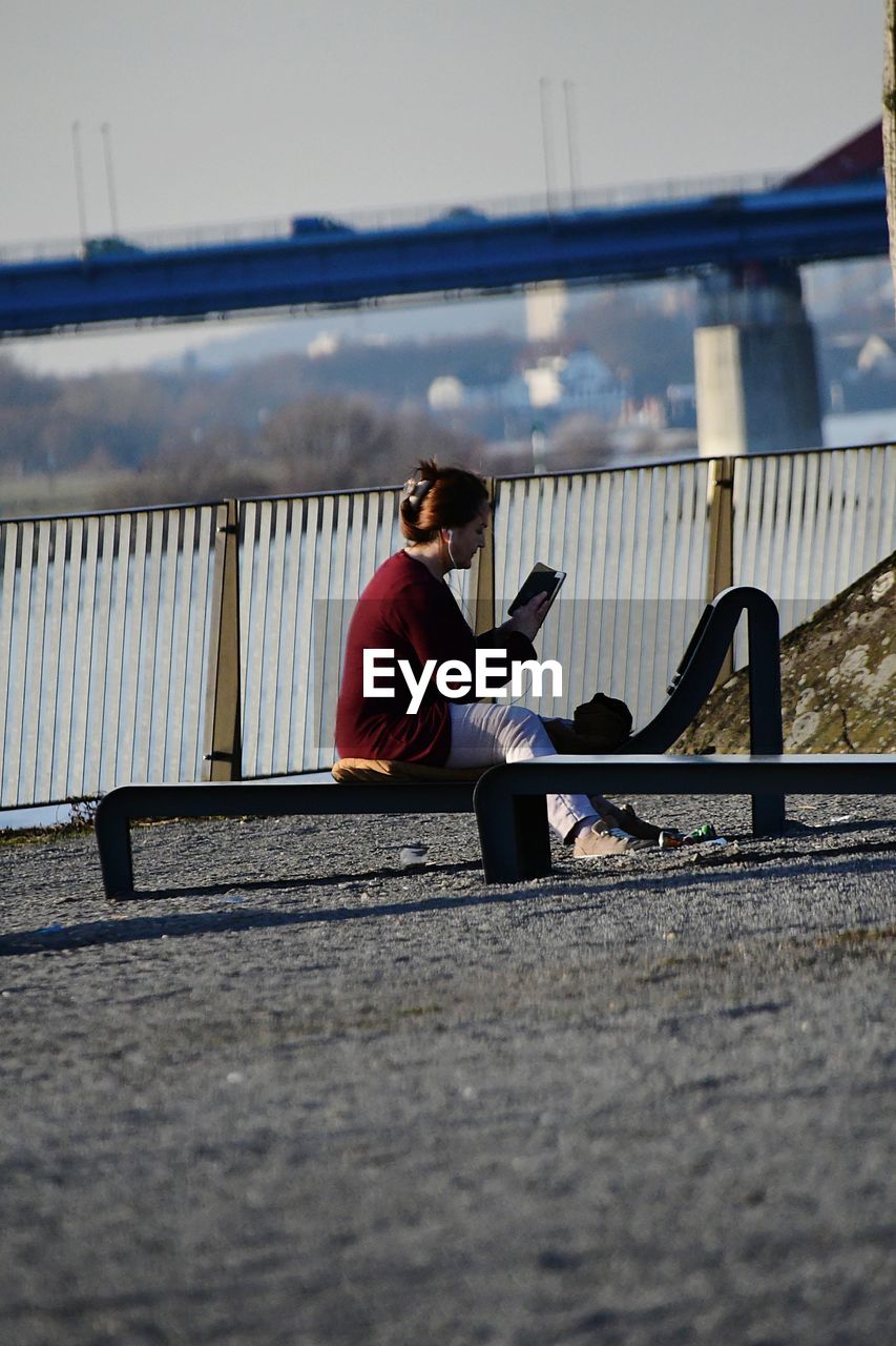 FULL LENGTH OF MAN SITTING ON BENCH