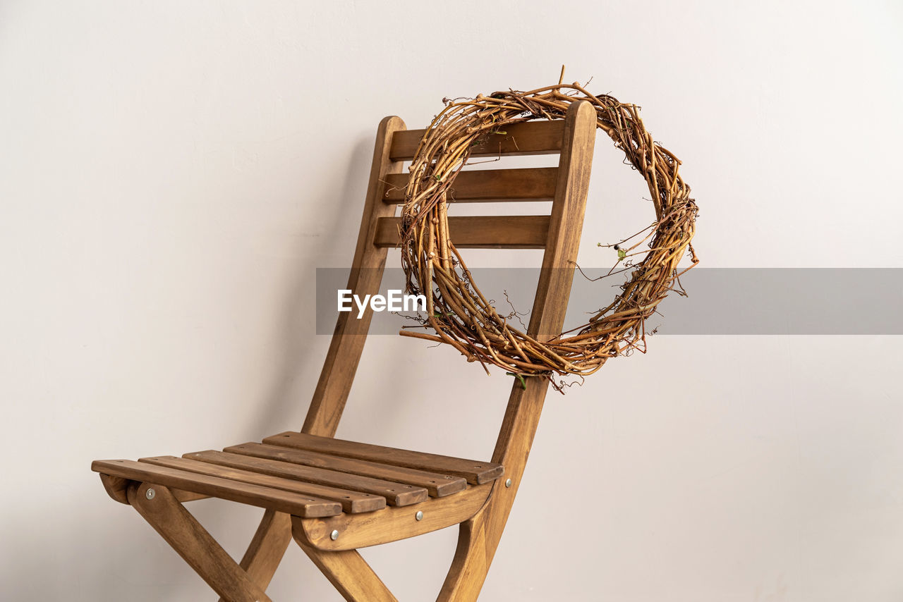 Christmas concept. minimal style. a wreath hanging on the wooden chair over grey background
