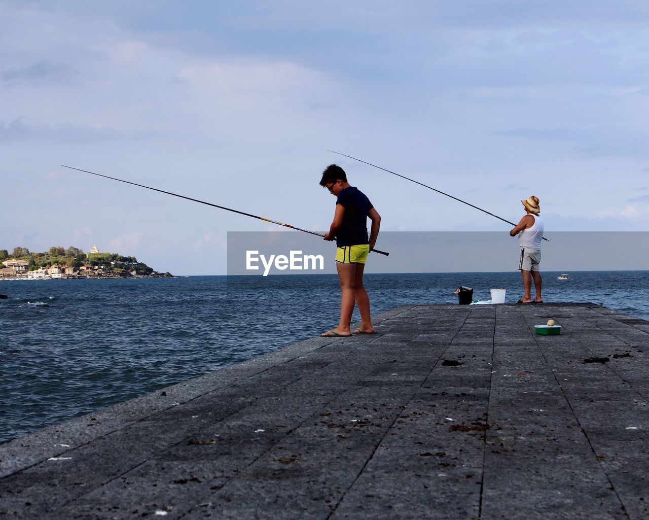 FRIENDS STANDING IN FRONT OF SEA