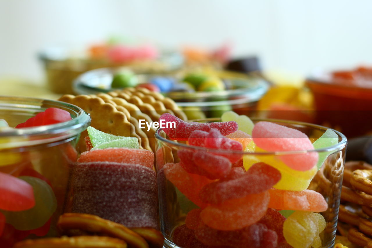 Close-up of sweets ans snacks wine gums cookies and chocolate peanuts served on table