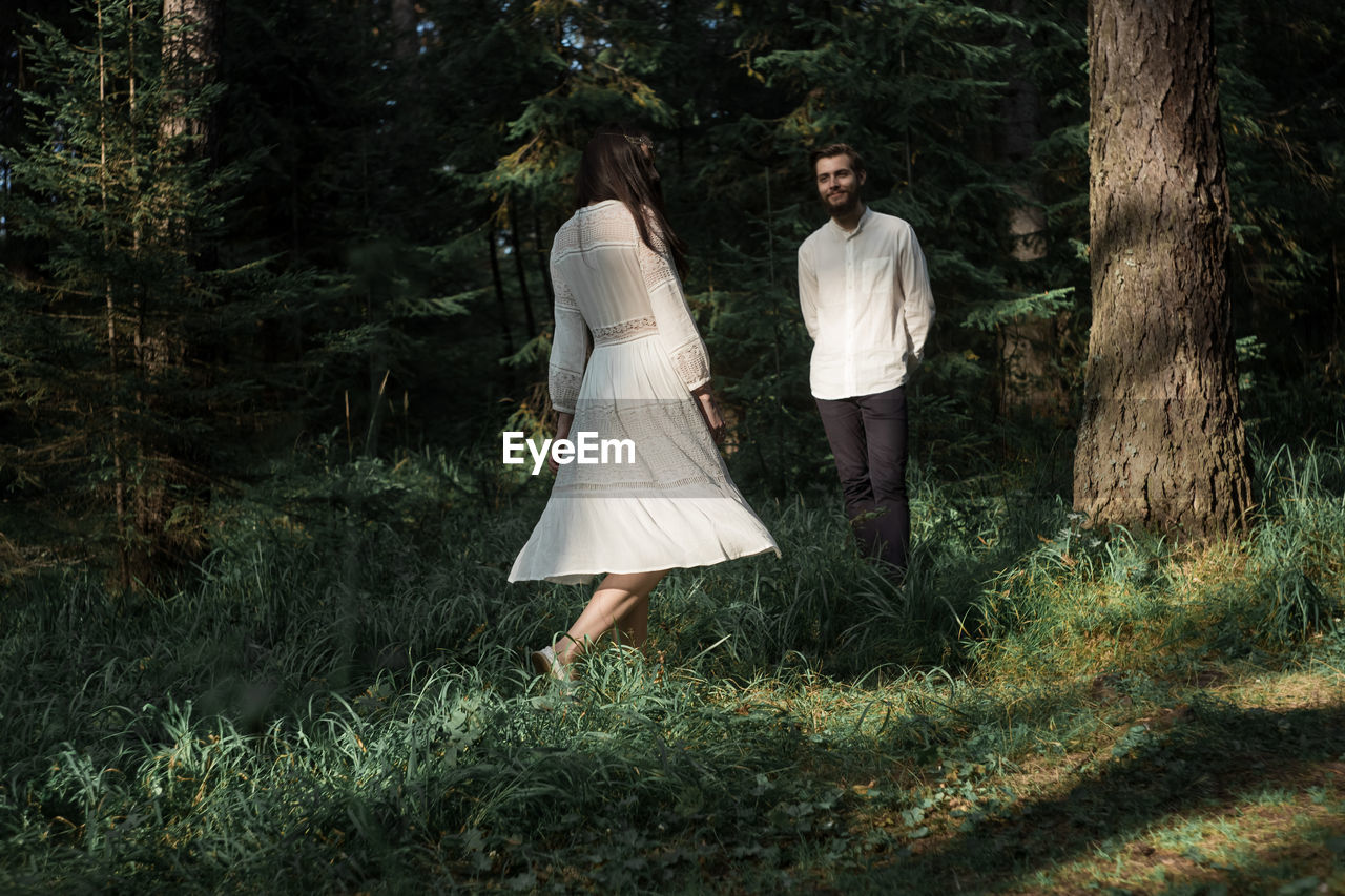 Smiling couple standing in forest