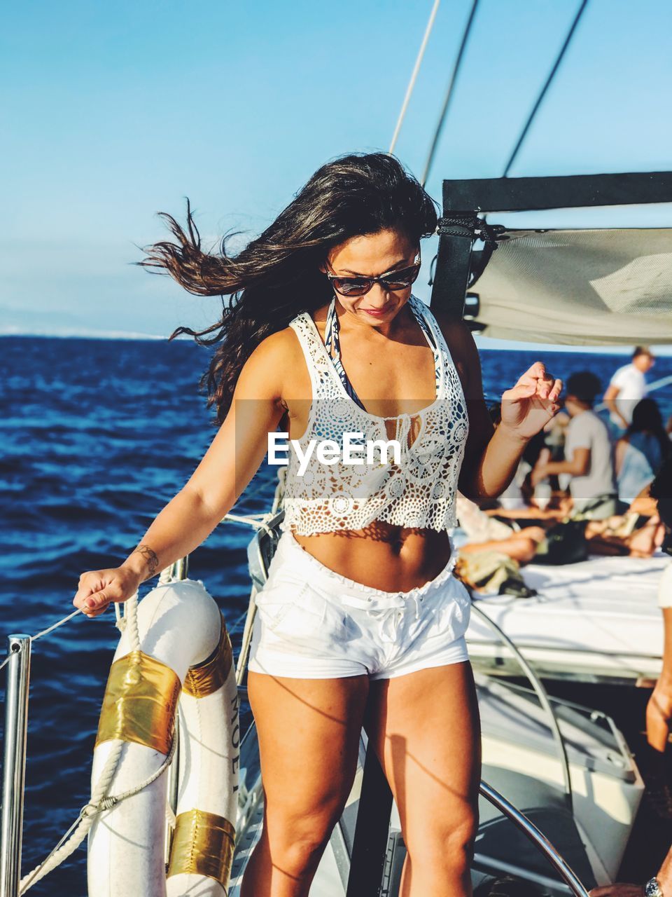 Young woman standing in boat on sea