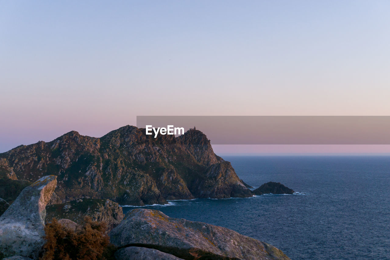Scenic view of rocks in sea against clear sky in cies islands