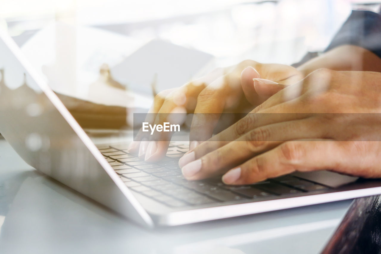 Close up image of man typing on laptop keyboard