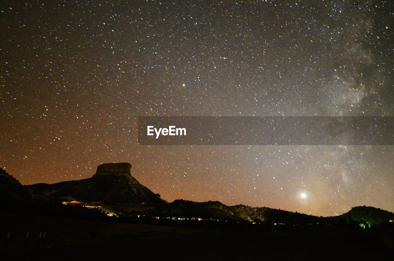 Low angle view of silhouette mountain against star field