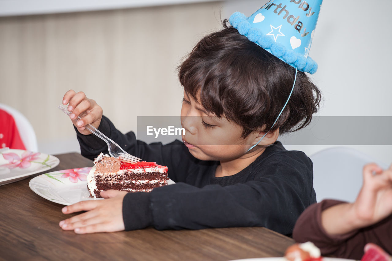 Close-up of boy eating birthday cake