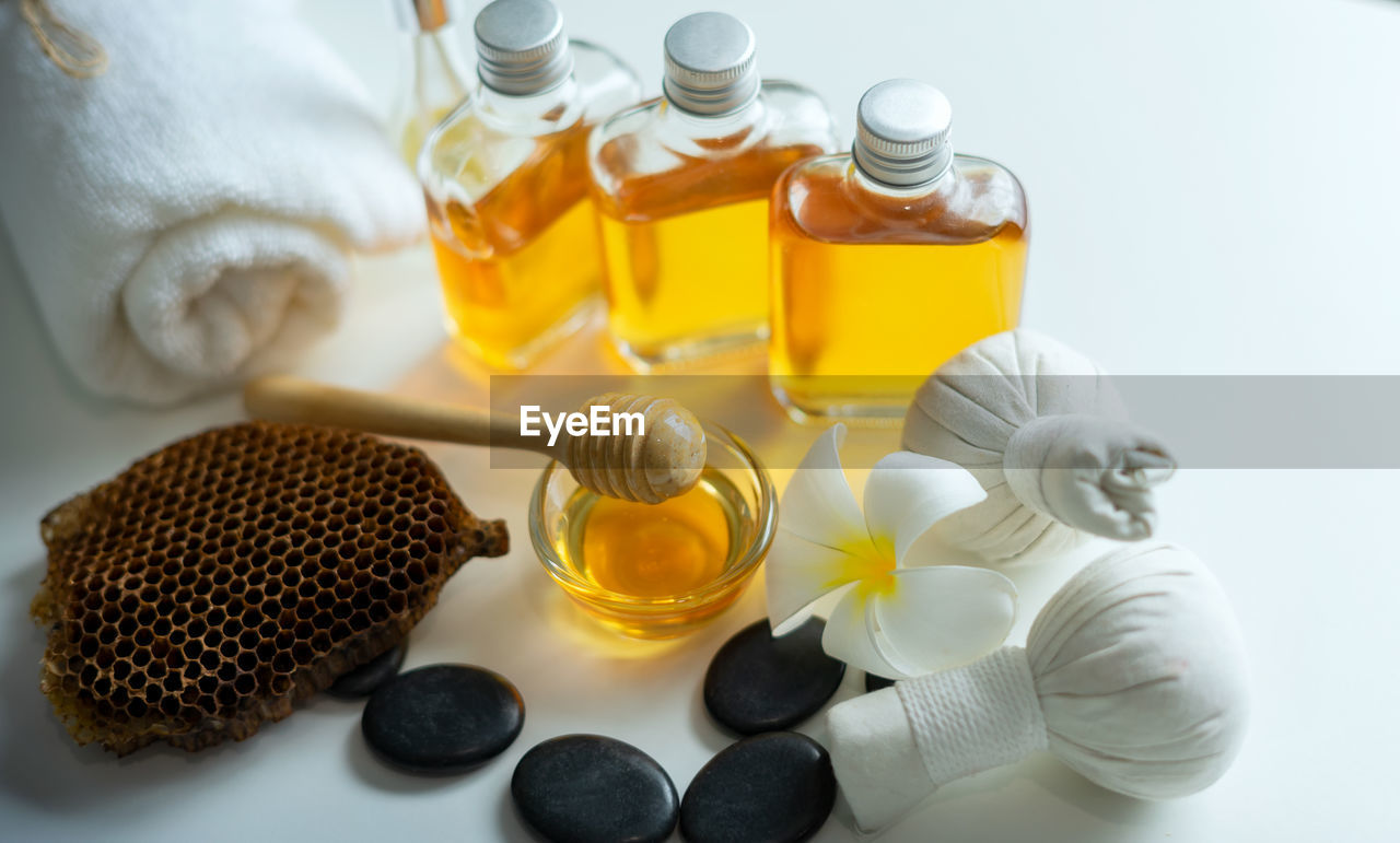 HIGH ANGLE VIEW OF BOTTLES ON TABLE AGAINST WHITE BACKGROUND