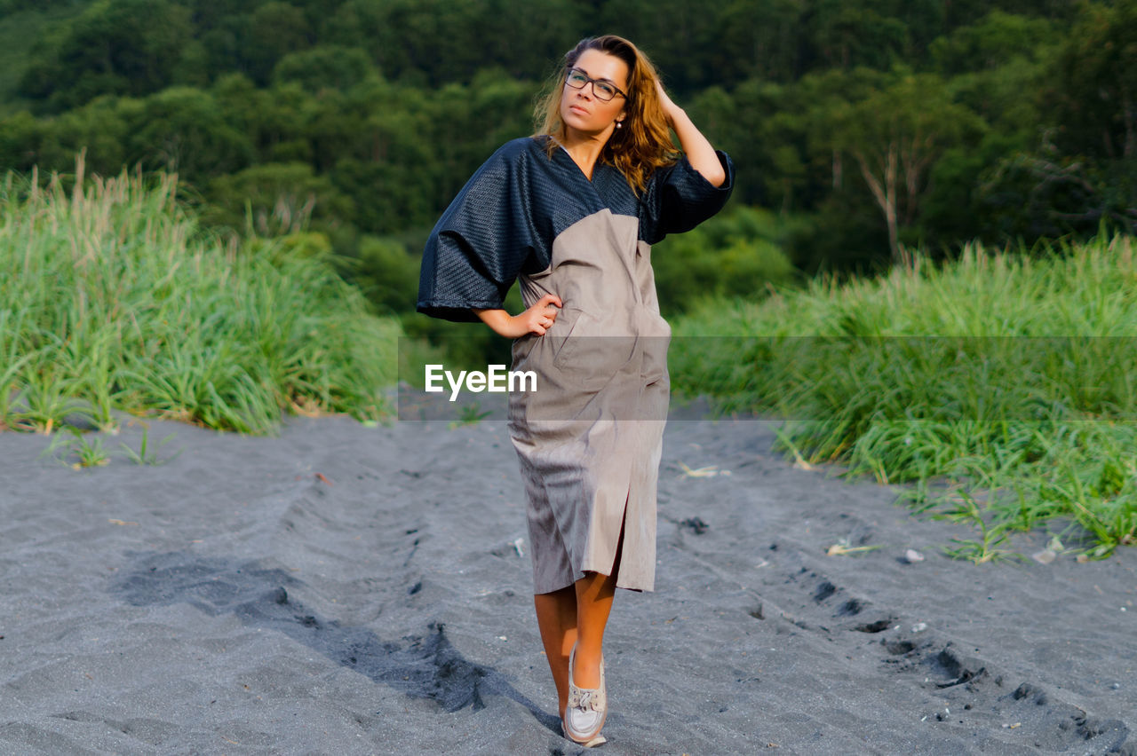 Portrait of mid adult woman standing on sand