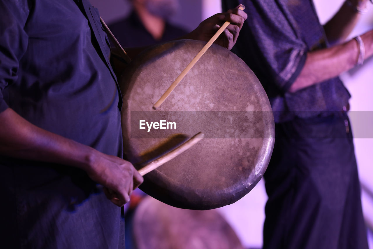 musician, adult, drum, music, musical instrument, midsection, holding, men, drummer, drum - percussion instrument, performance, purple, skill, arts culture and entertainment, membranophone, occupation, percussion, musical equipment, focus on foreground, one person, event