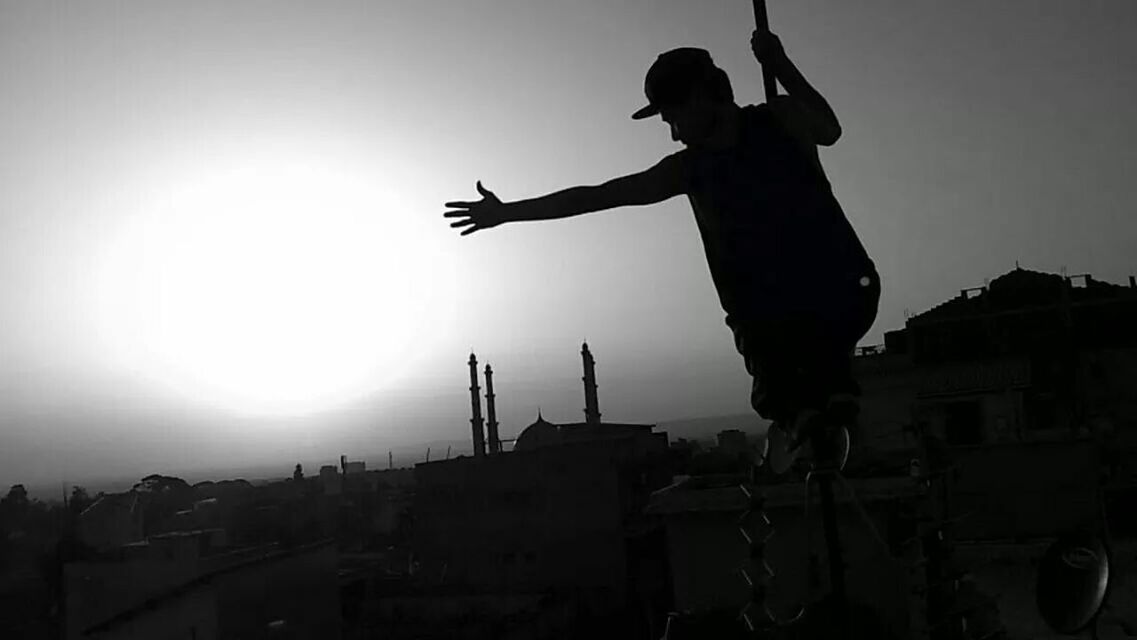 LOW ANGLE VIEW OF WOMAN STANDING AGAINST SKY