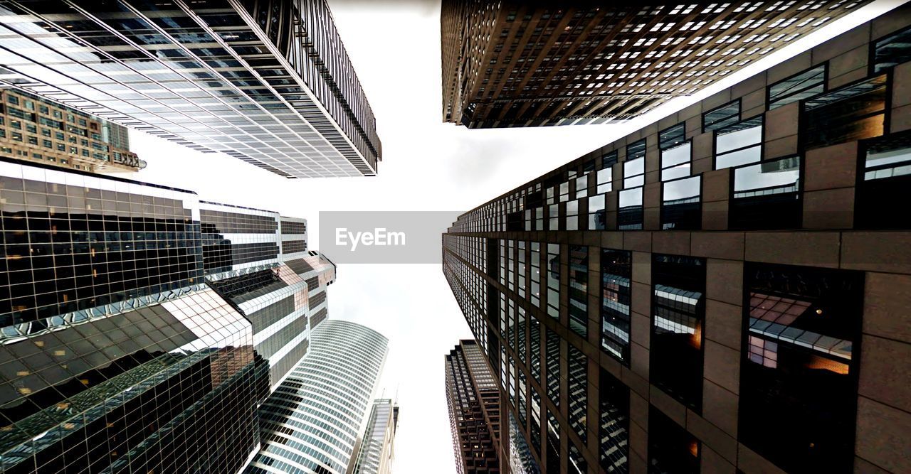 Directly below shot of modern buildings against sky in city