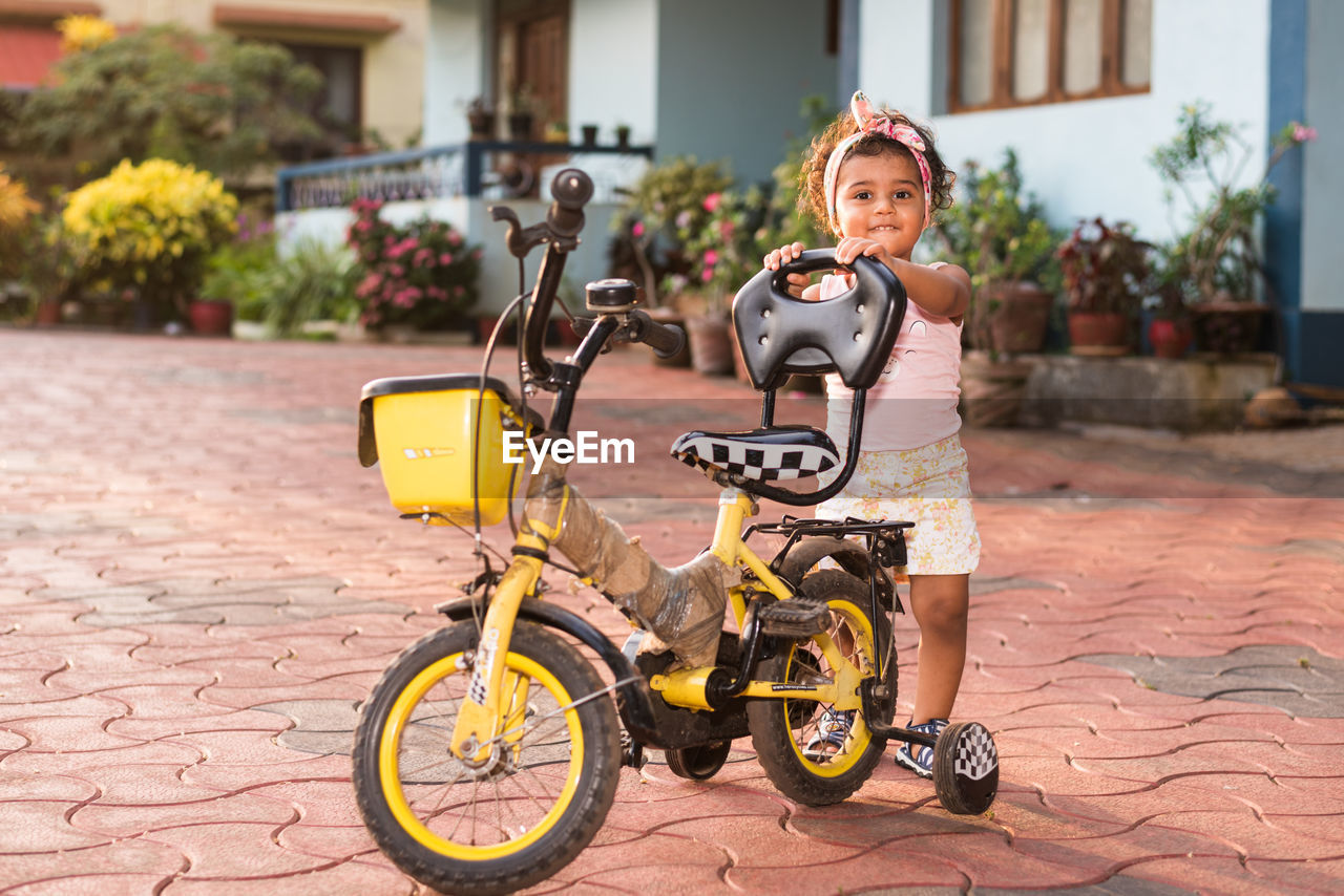 Portrait of boy riding bicycle on street