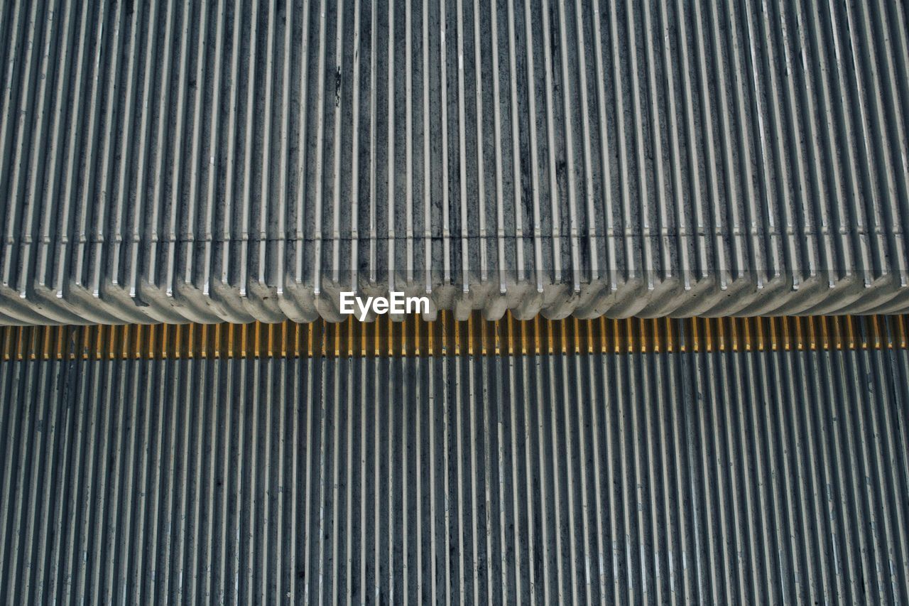 HIGH ANGLE VIEW OF ESCALATOR ON METAL GRATE