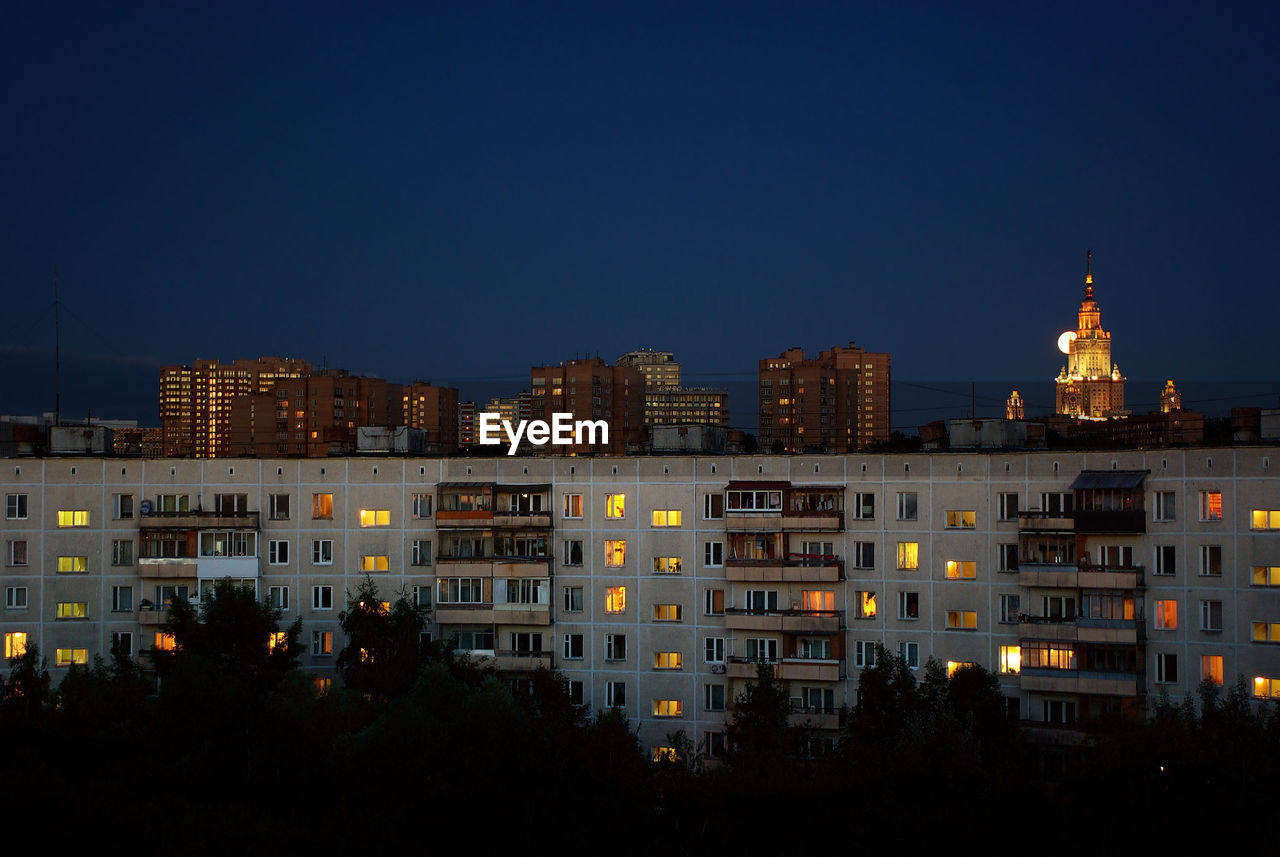 Night view of the round house in moscow, with moon and moscow state univercity at the background