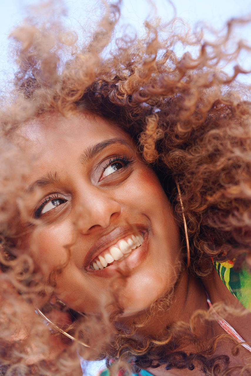 Low angle portrait of black woman with curly hair
