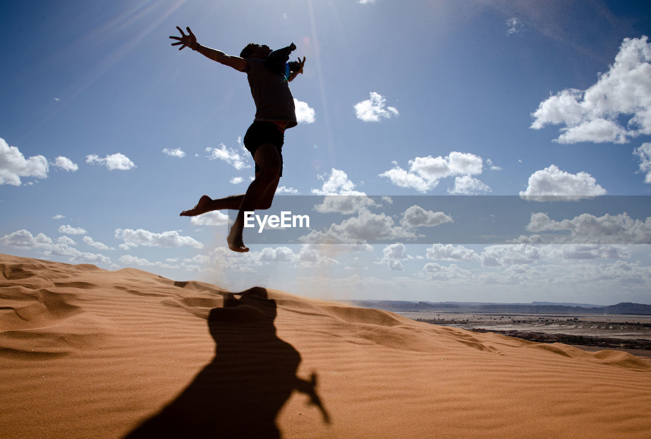 Man in the desert, happy and jumps, jumping in the desert celebrating her freedom