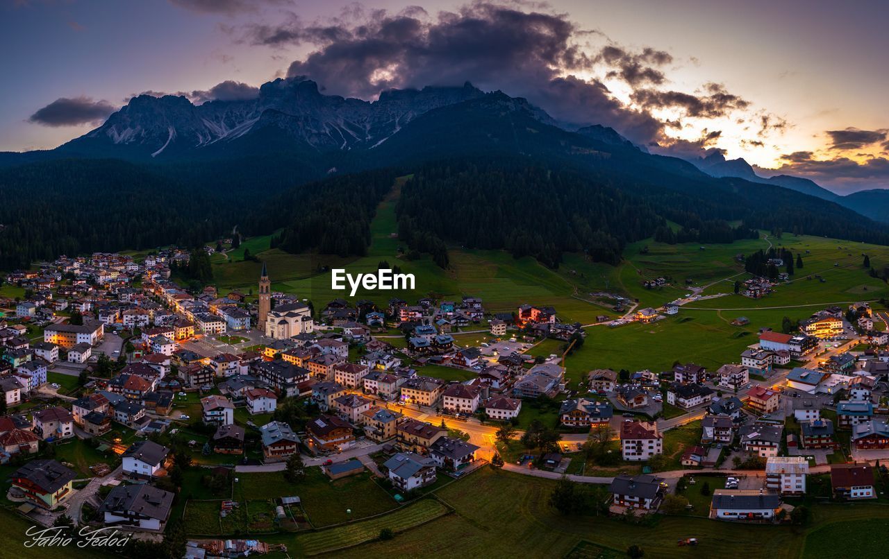 Aerial view of townscape and mountains against sky